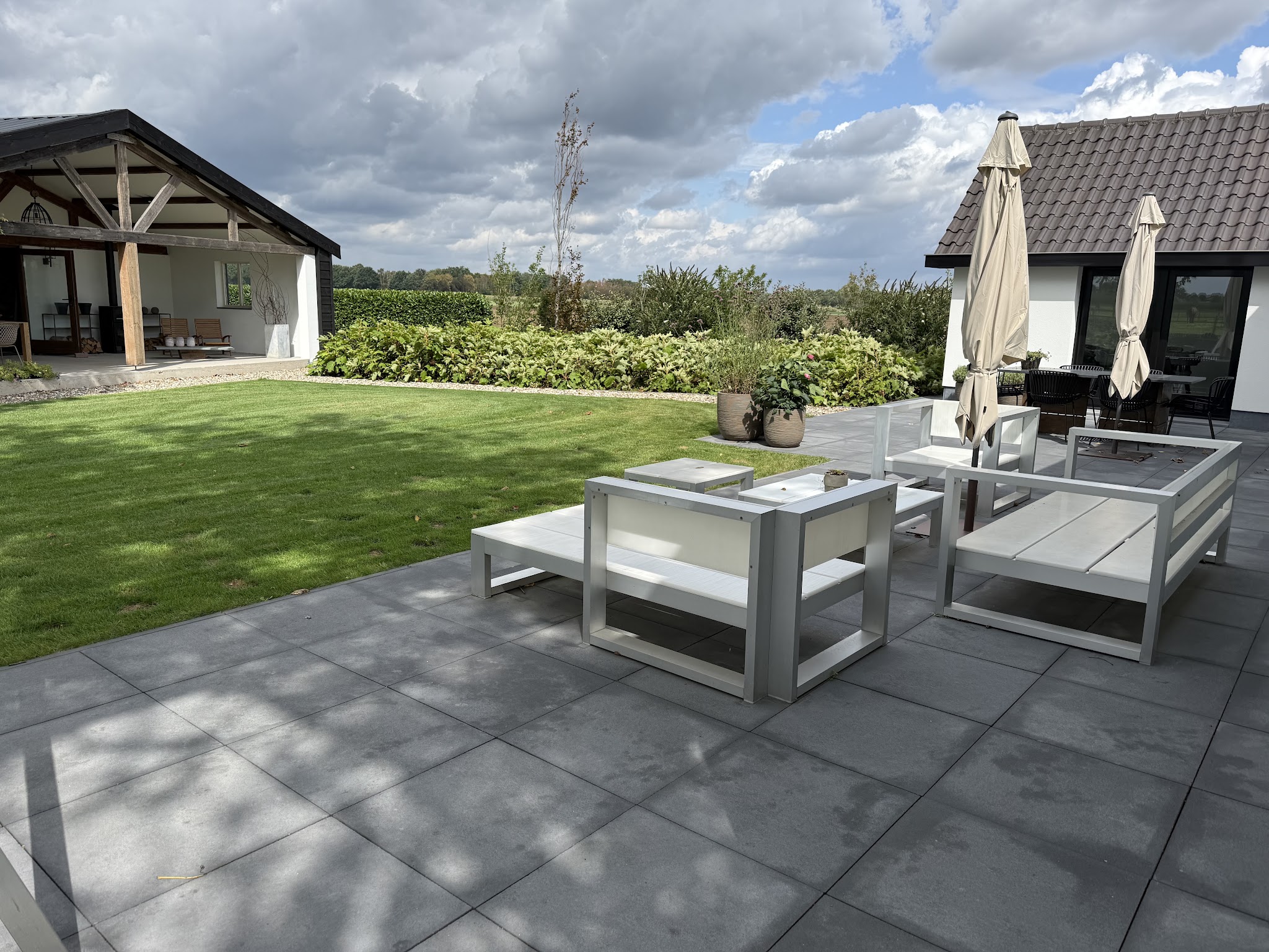 Terras met loungeset aan de rand van het gazon